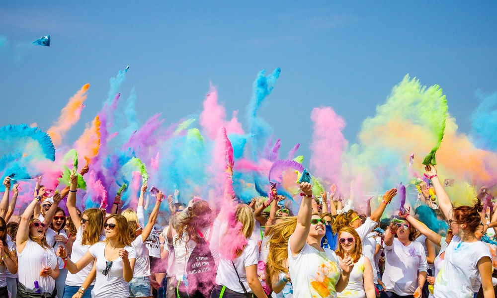 People celebrating Holi festival in India with colorful powder in the air